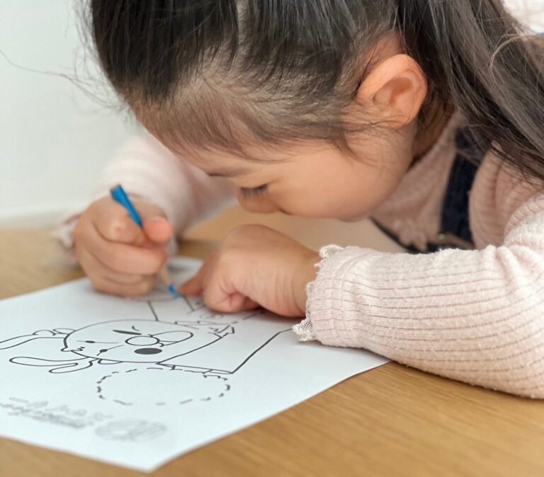 制作事例のイラストで塗り絵をする園児