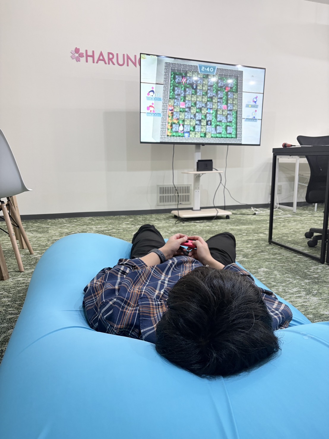 事務所のヨギボーでボンバーマンを楽しむスタッフ